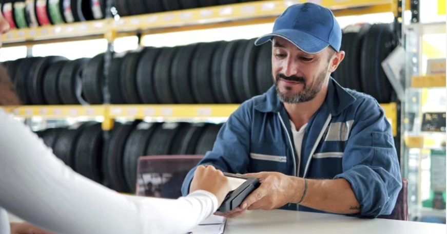 Auto shop manager accepting credit card payment from customer