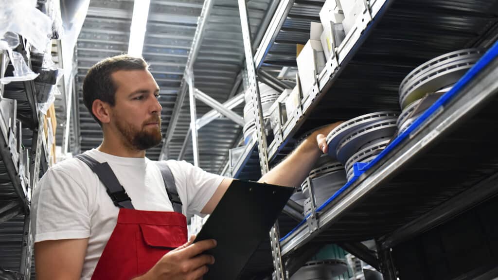 friendly worker in a warehouse and trade for car spare parts of a car repair shop