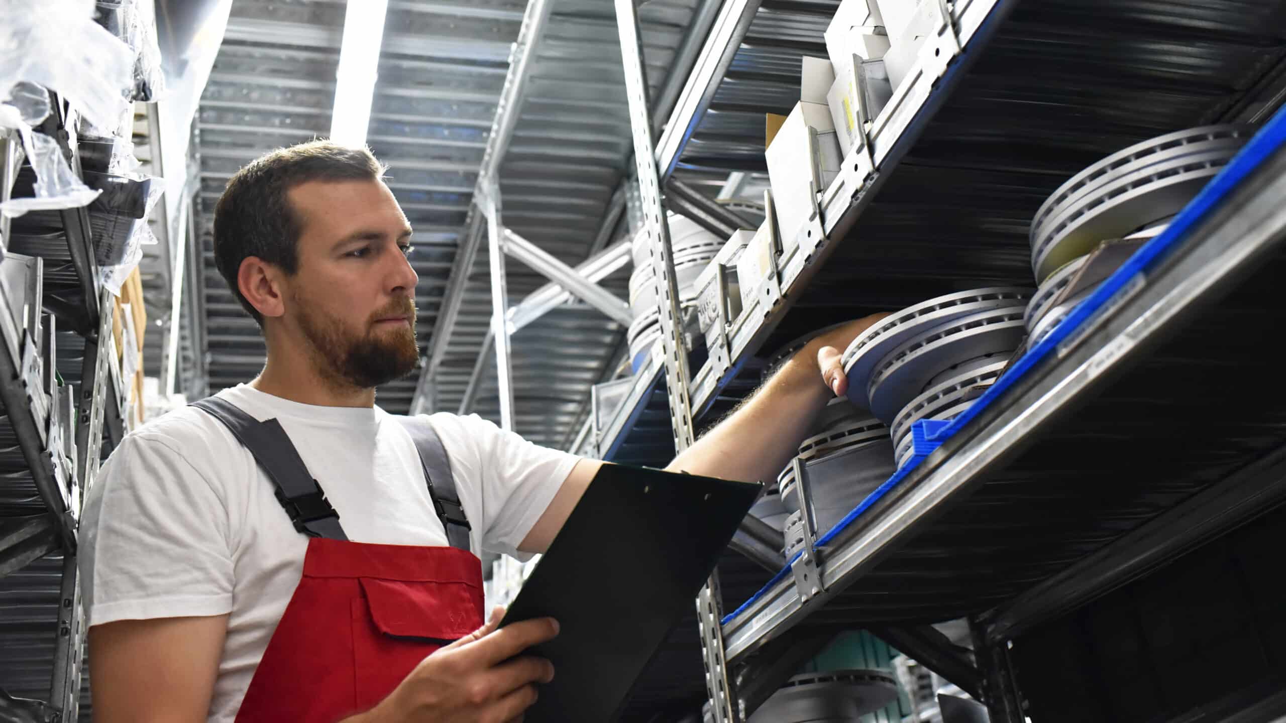 friendly worker in a warehouse and trade for car spare parts of a car repair shop